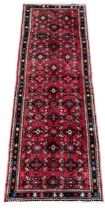 A PERSIAN DESIGN RED GROUND RUNNER Decorated with stylised patterns. (69cm x 190cm)
