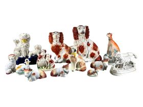 A COLLECTION OF THIRTEEN 19TH CENTURY AND LATER STAFFORDSHIRE/POTTERY ANIMALS To include dogs, cows,