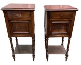 A PAIR OF LATE 19TH CENTURY FRENCH WALNUT BEDSIDE CUPBOARDS The inserted marble tops above a