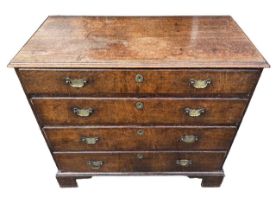 A GEORGE III OAK CHEST Of four long graduated drawers, fitted with swan neck handles, raised on