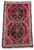 A SHIRAZ RED GROUND PRAYER RUG Decorated with stylised geometrical patterns. (78cm x 128cm)