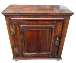 A 17TH CENTURY OAK SPICE/FOOD CUPBOARD The panel door opening to reveal shelf interior fitted with