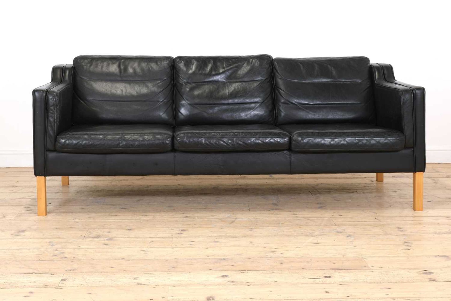 A Danish black leather three-seater settee,