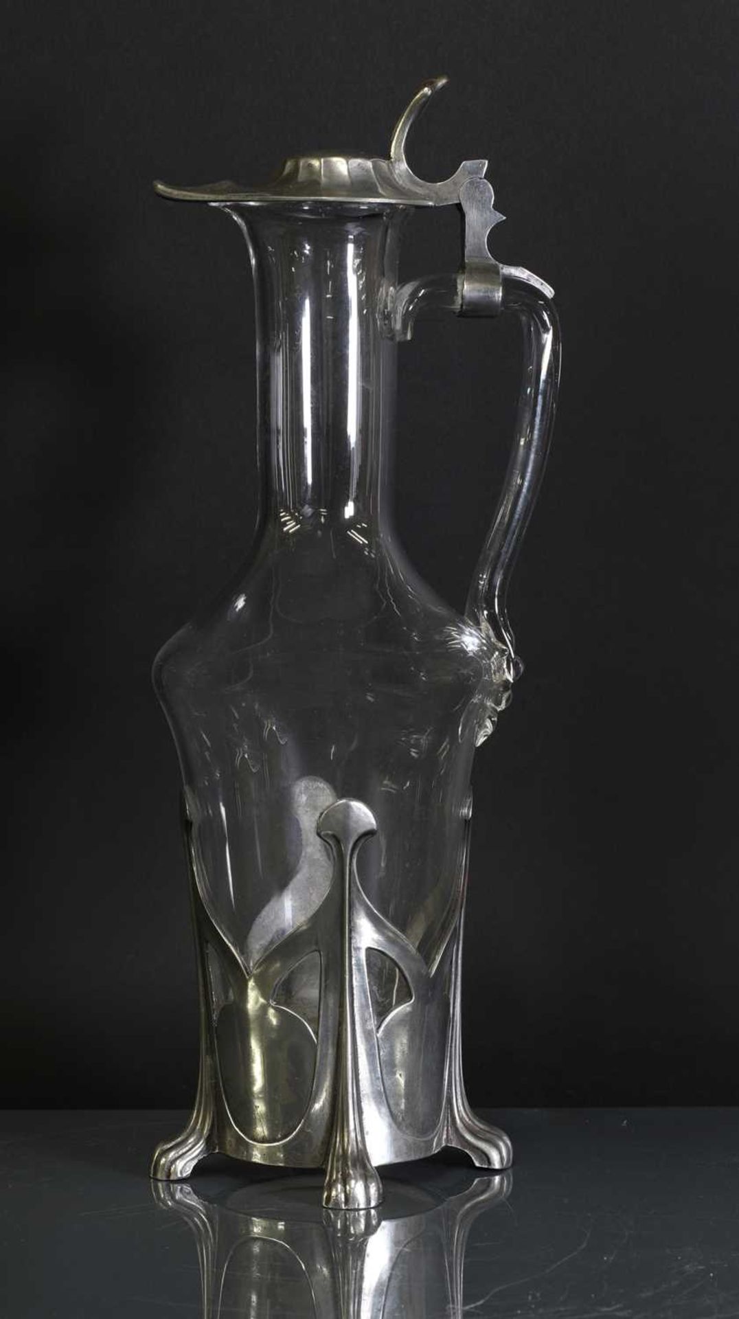 An Art Nouveau pewter and glass claret jug,