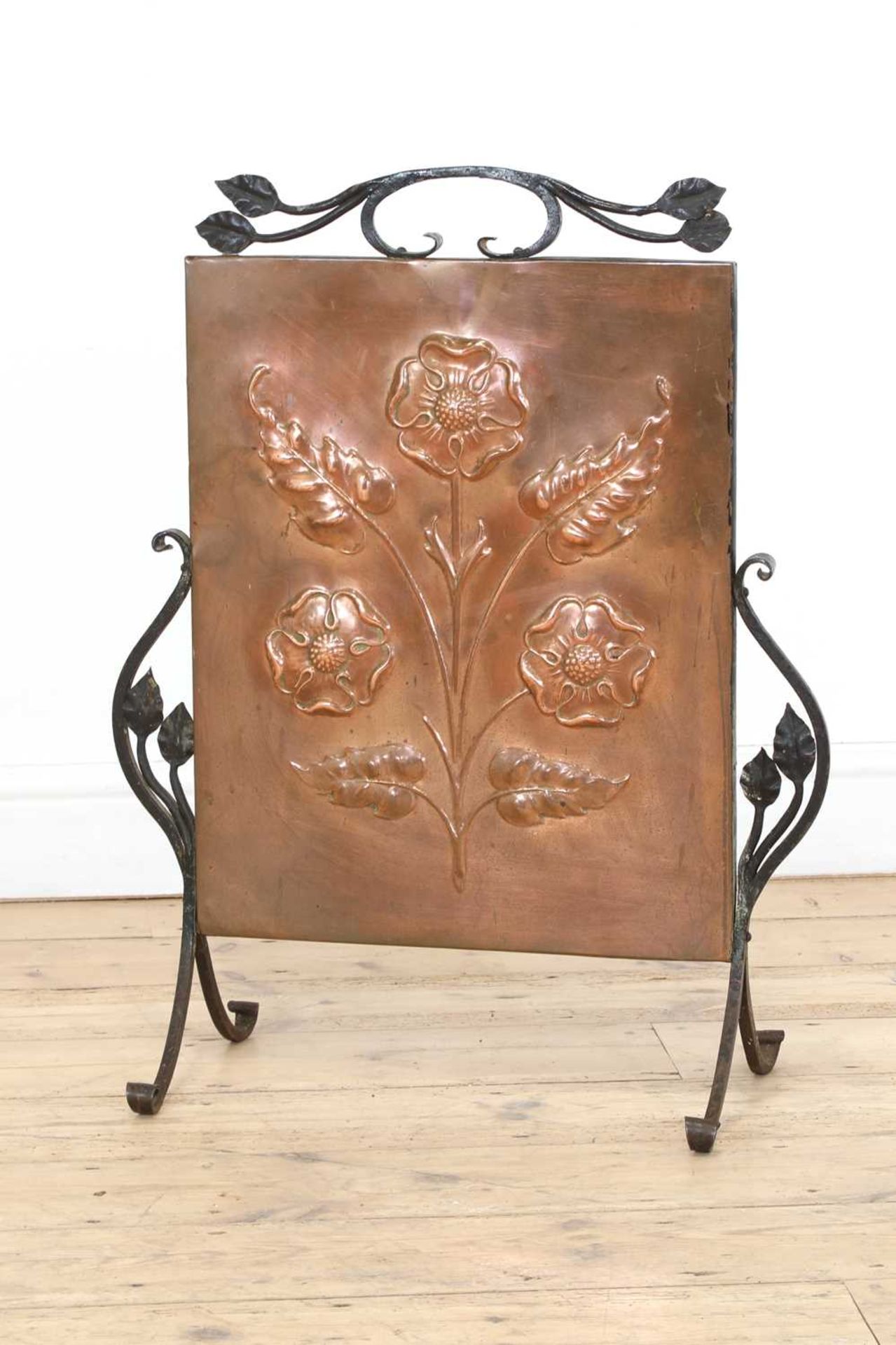 An Arts and Crafts copper embossed fire screen,