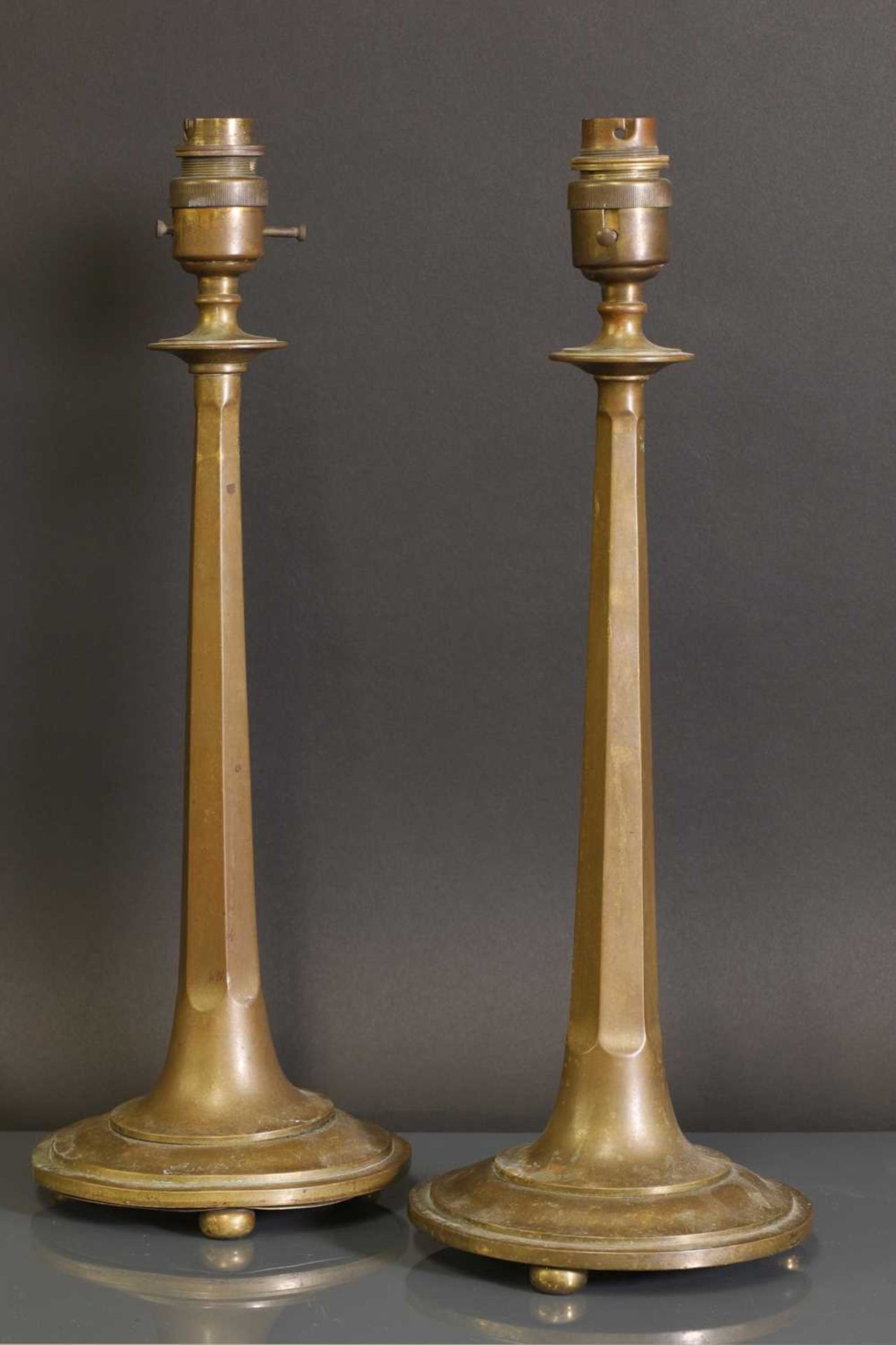 A pair of Arts and Crafts bronze candlesticks,