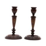 A pair of rosewood candlesticks