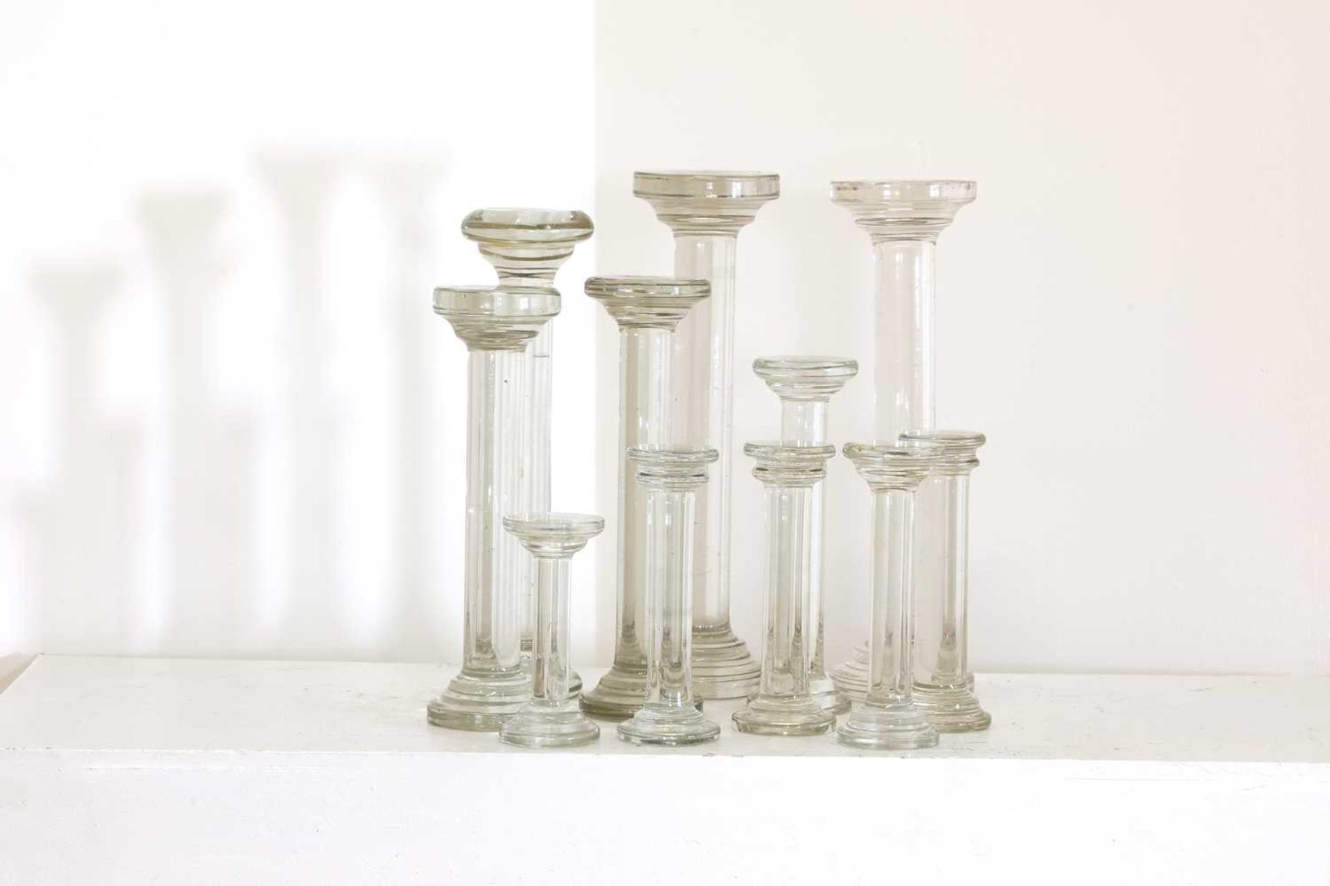 A collection of eleven glass cake stands,