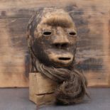 Lega society: a carved and patinated mask,