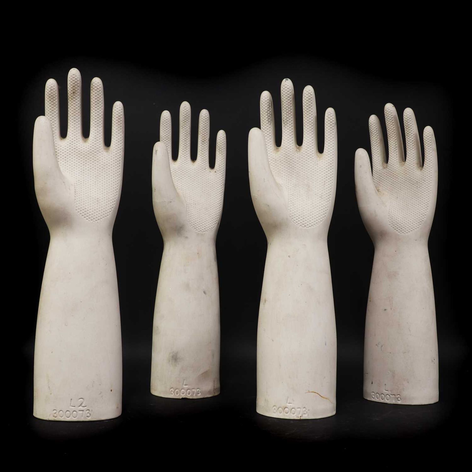 A set of four porcelain rubber glove moulds,