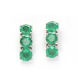 A pair of 9ct white gold three stone emerald earrings,