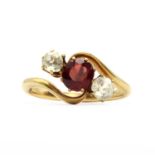 An Edwardian three stone garnet and white sapphire crossover ring,