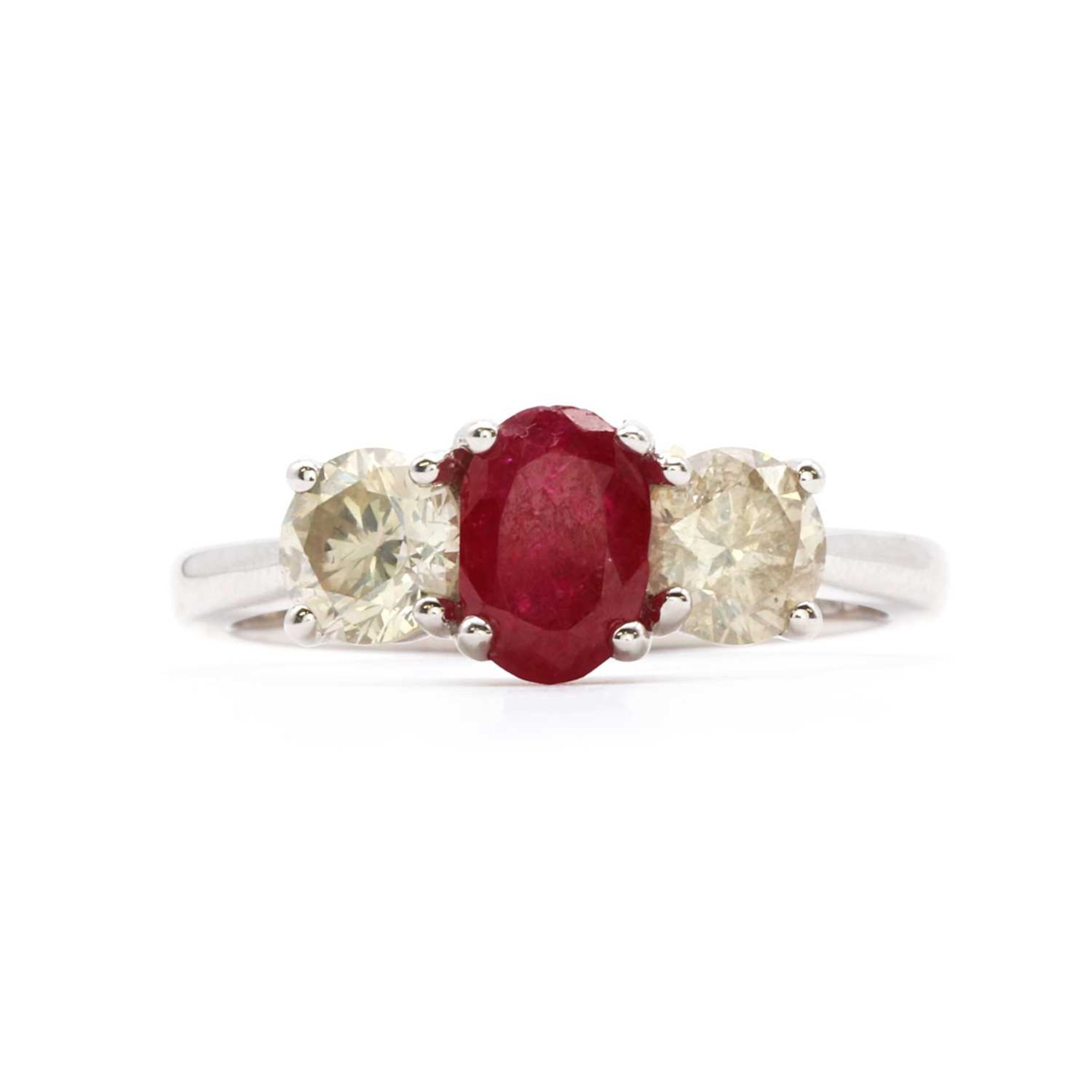 An 18ct white gold three stone fracture filled ruby and diamond ring,