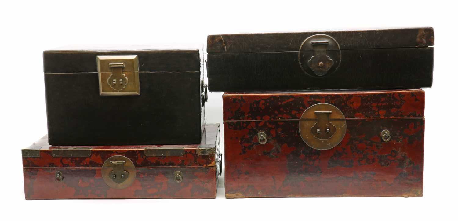 A collection of four Chinese lacquered leather trunks,