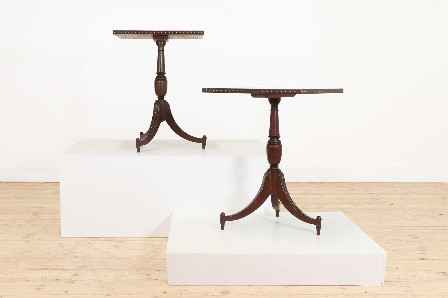 A pair of teak tripod occasional tables,