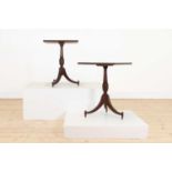 A pair of teak tripod occasional tables,