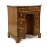 A George I style strung walnut kneehole desk,