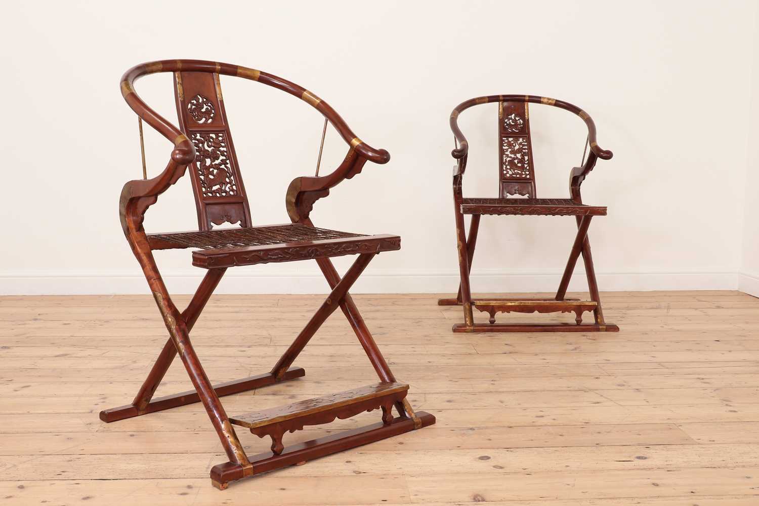 A pair of Chinese hardwood horseshoe-back folding chairs,