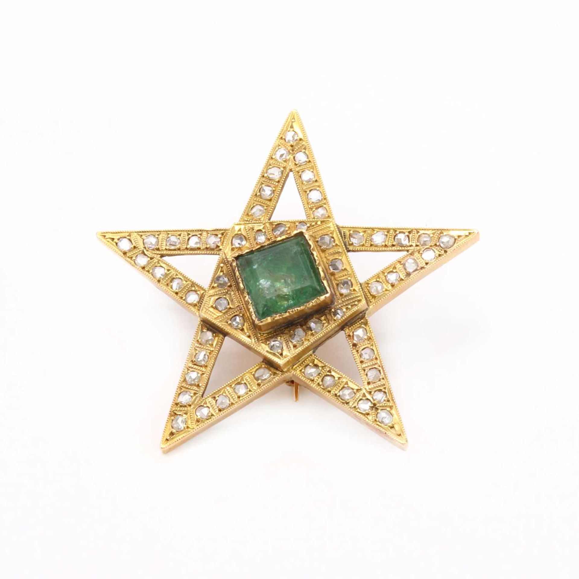 A gold emerald and diamond star brooch,