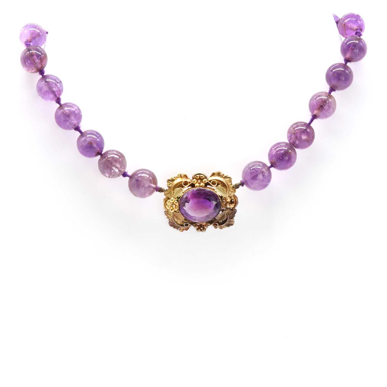 A graduated circular amethyst bead necklace with an amethyst brooch centrepiece,