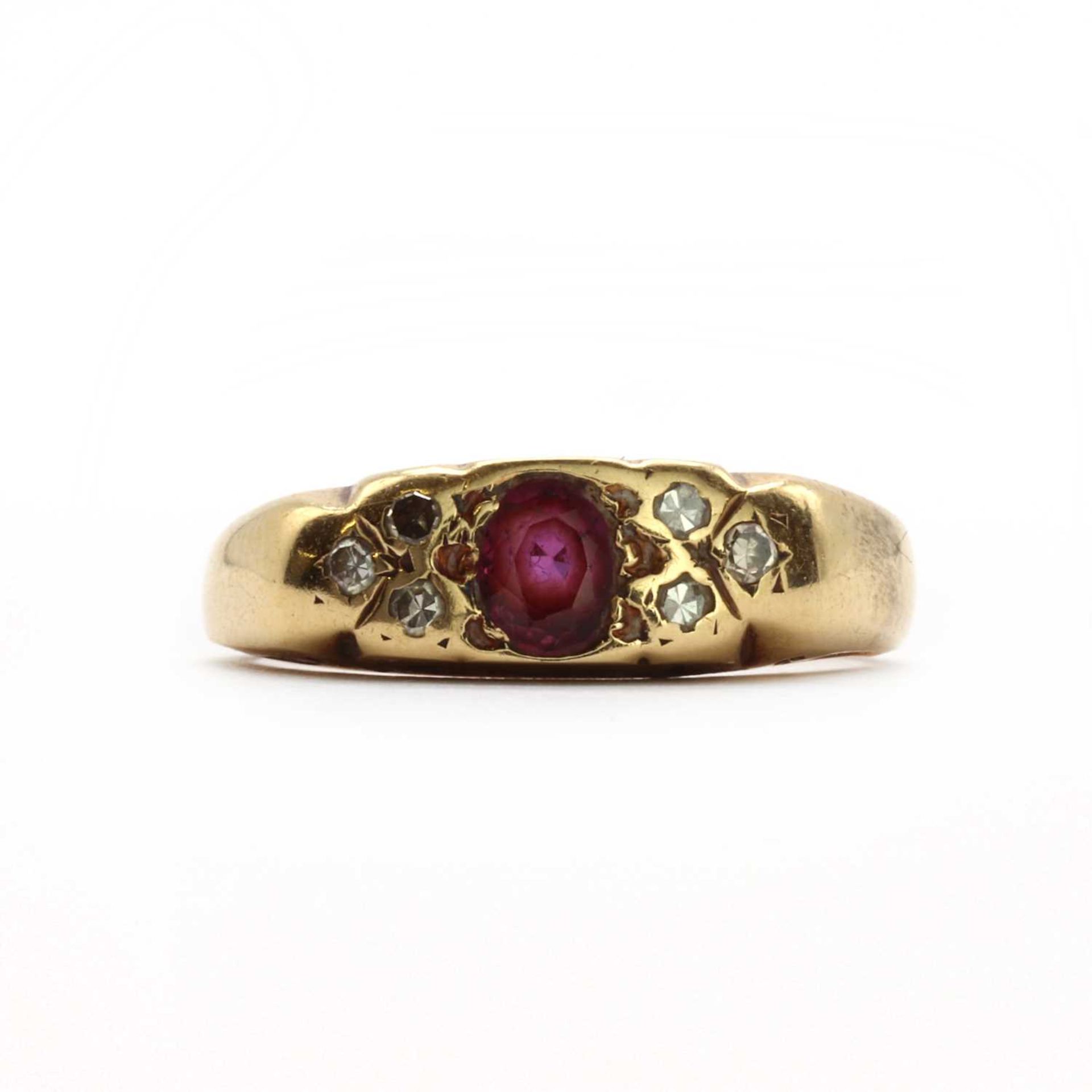 A gold ruby and diamond carved head ring,