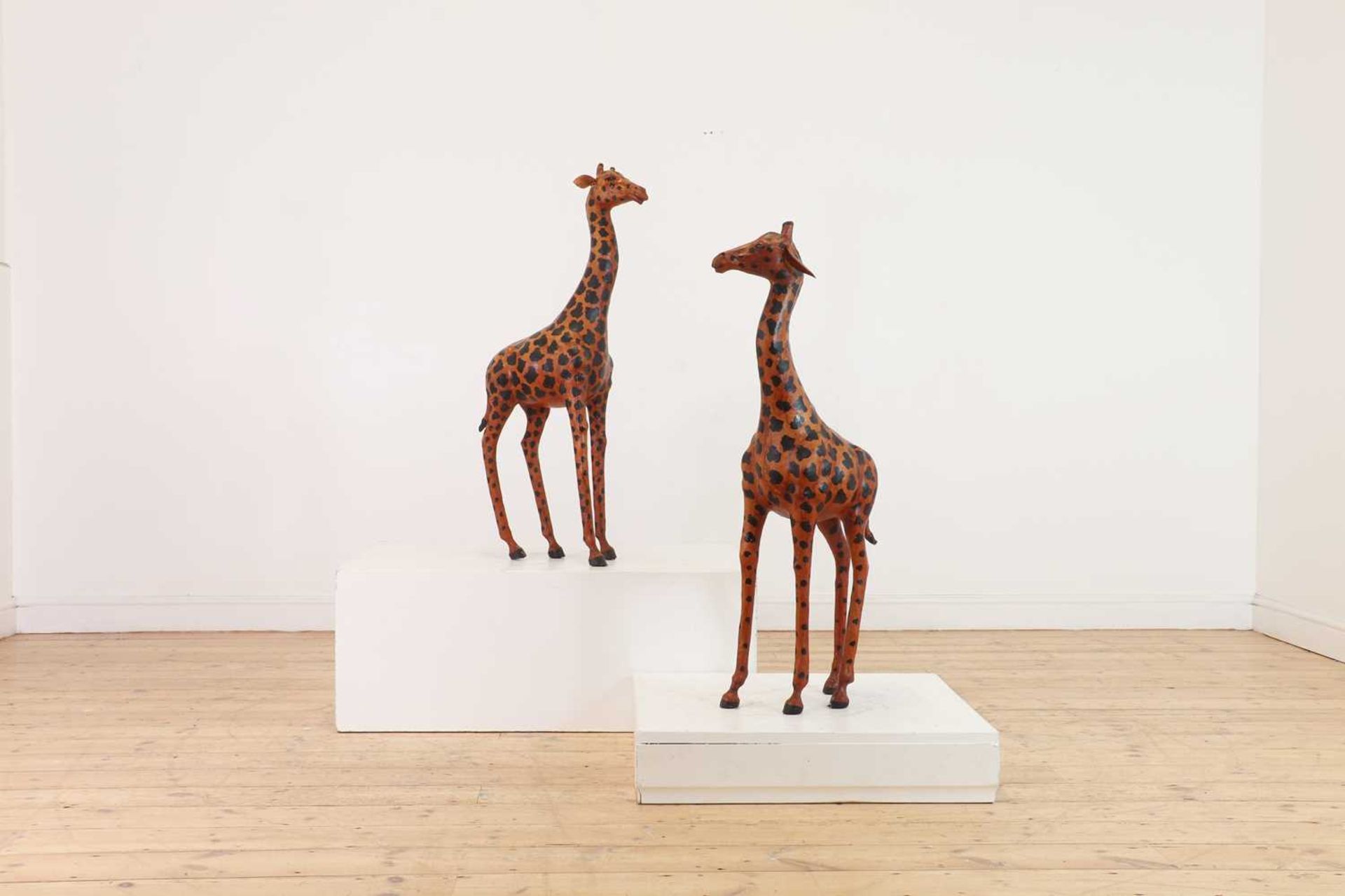 A pair of painted hide figures of giraffes,