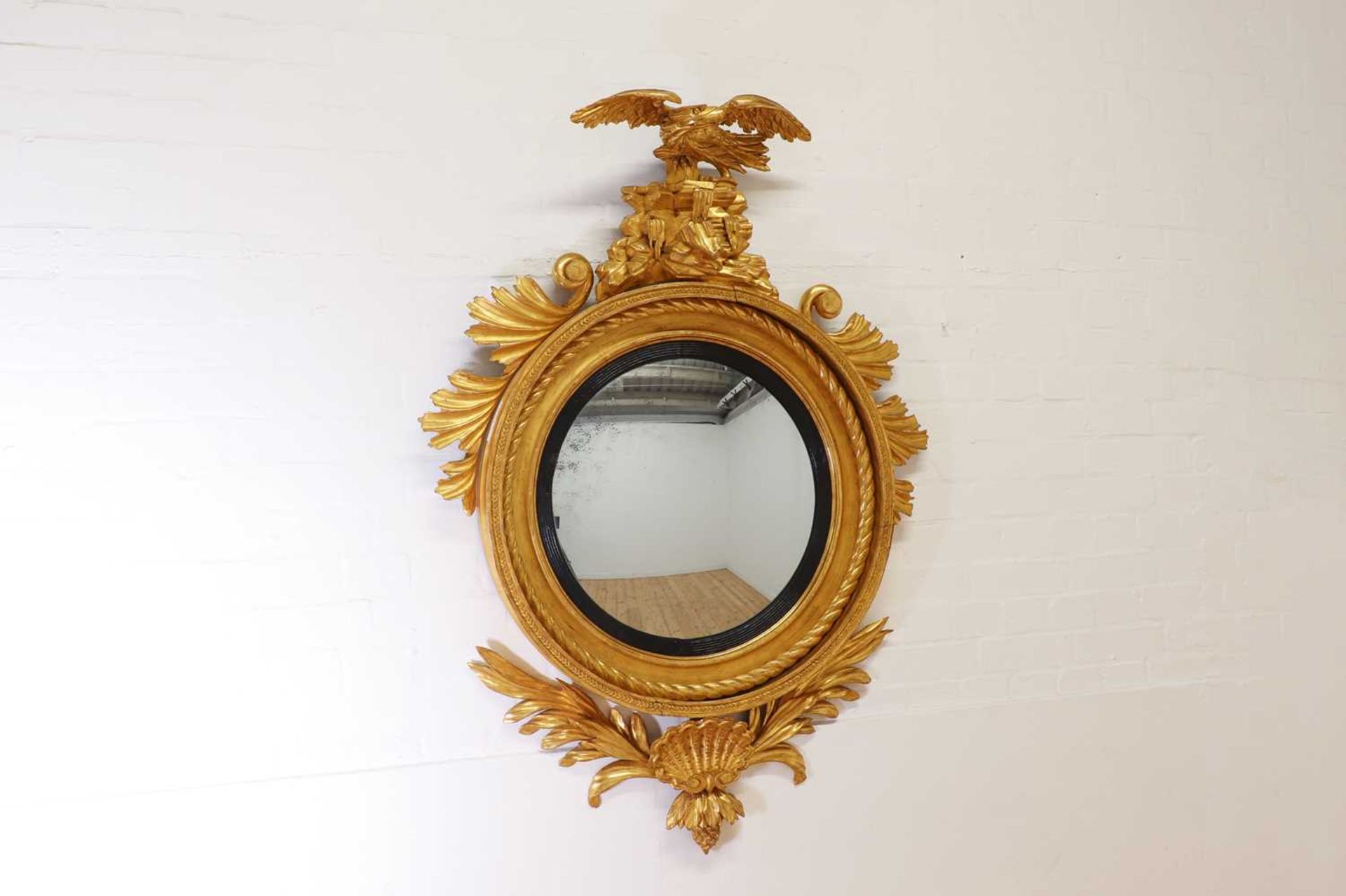 A Regency carved giltwood convex mirror,