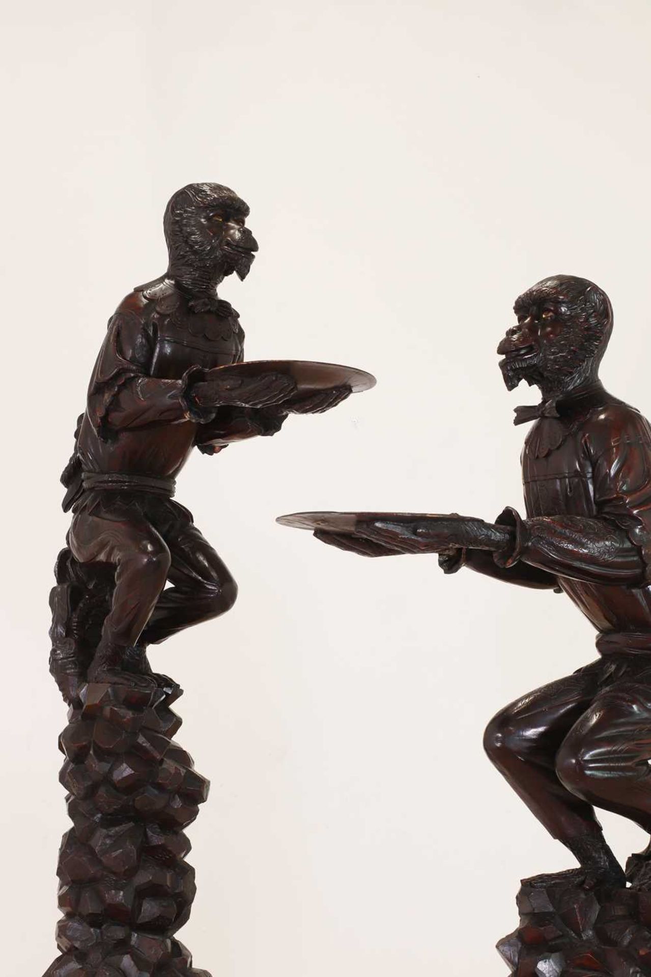 A pair of large carved walnut monkey waiters