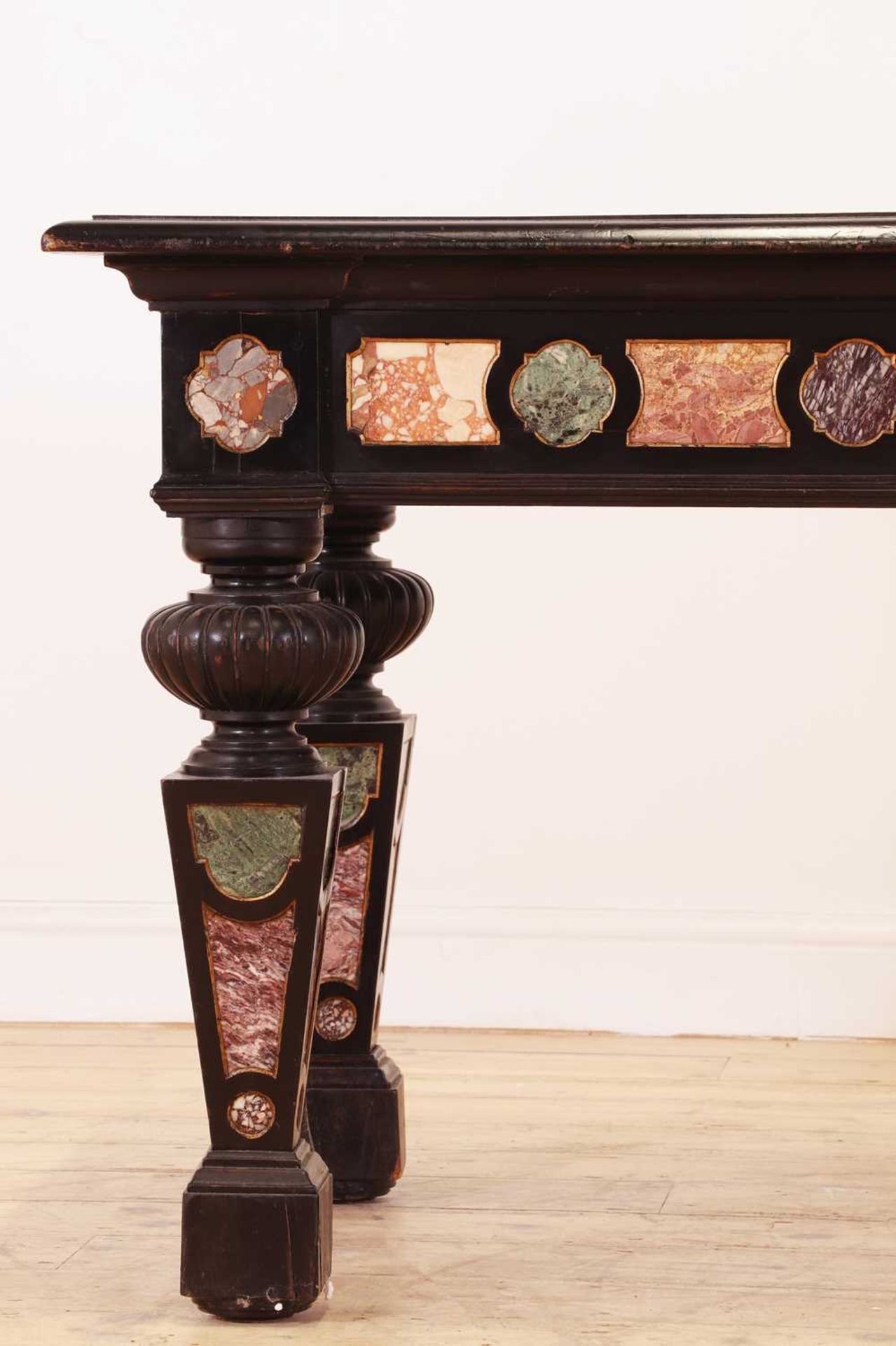 An ebonised, specimen and parcel-gilt console table,