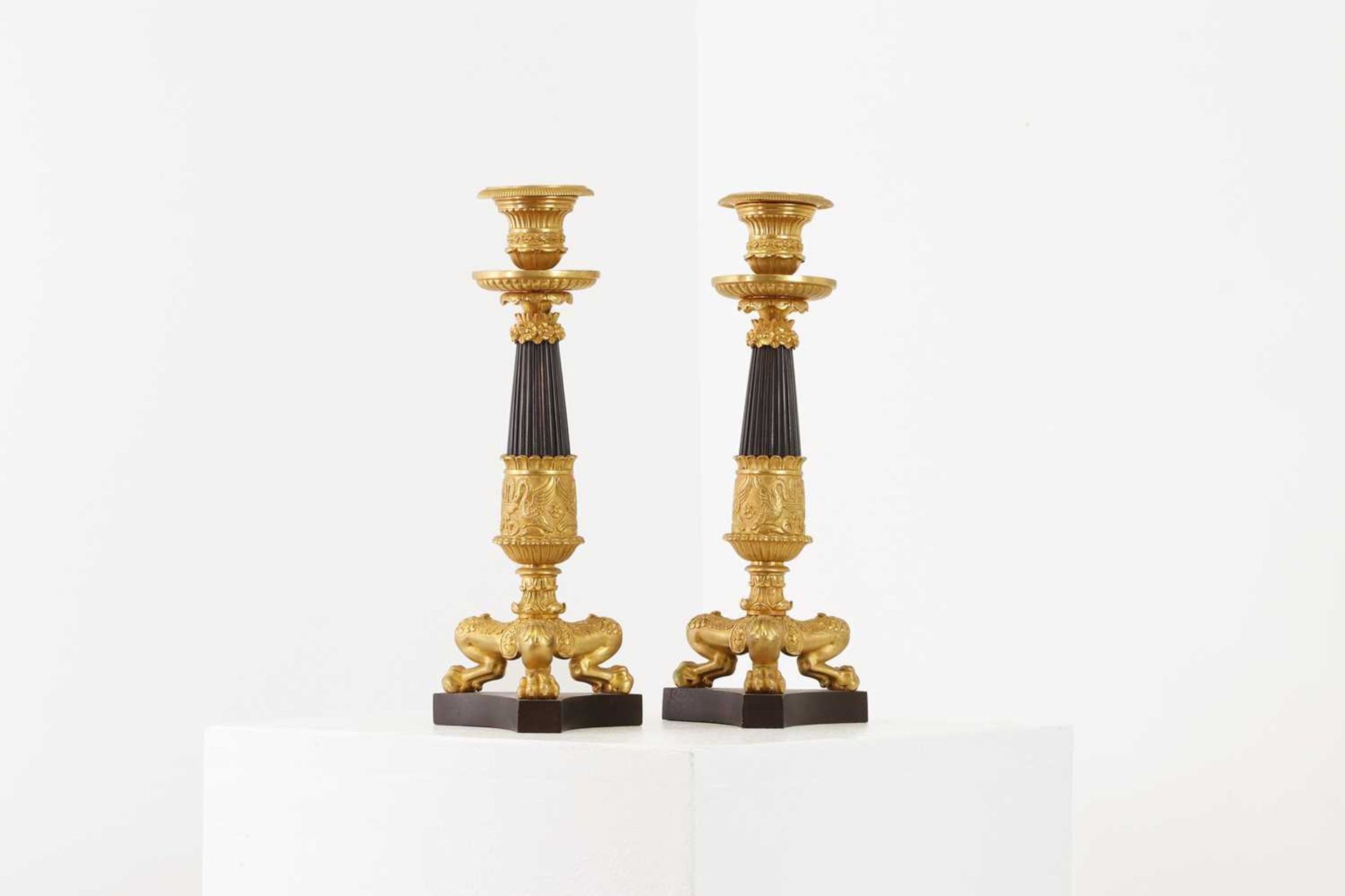 A pair of Regency-style bronze and parcel-gilt candlesticks,