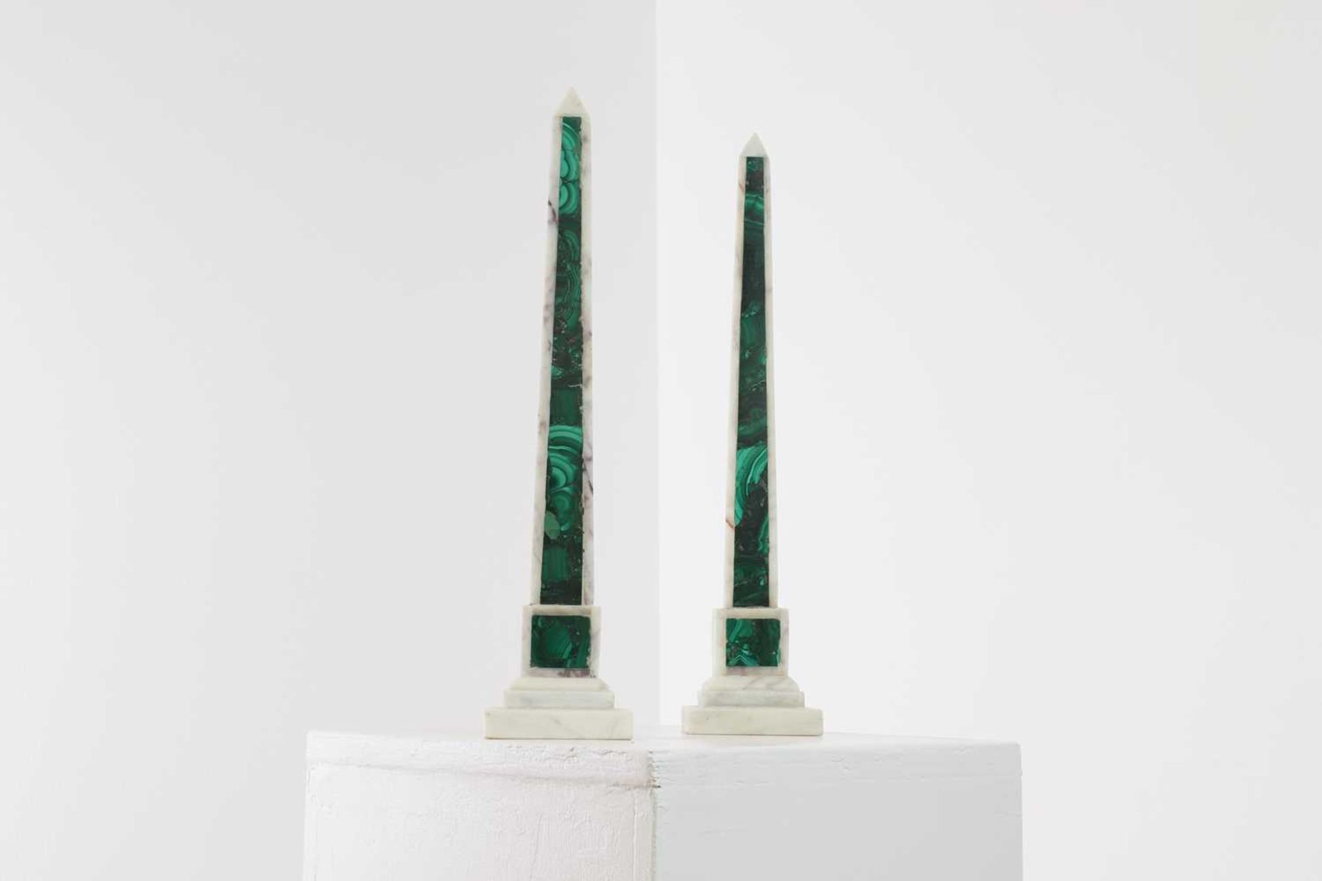 A pair of white marble and malachite obelisks