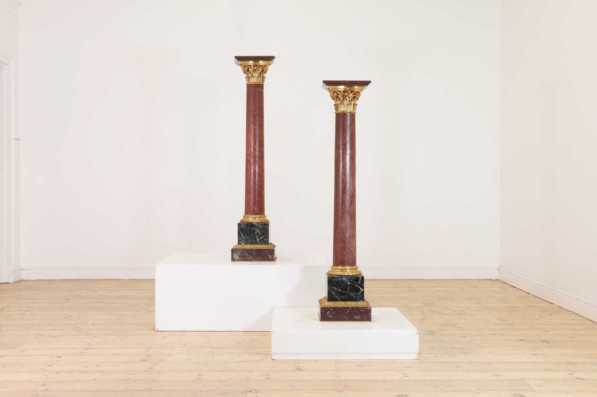 A pair of rouge marble pedestals,