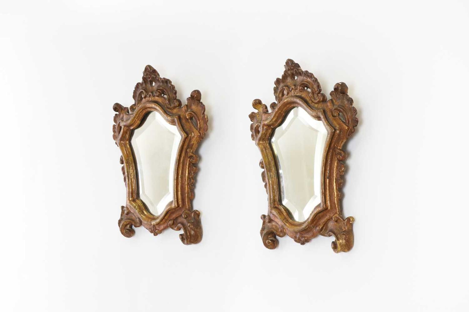 A pair of baroque-style parcel-gilt wall mirrors,