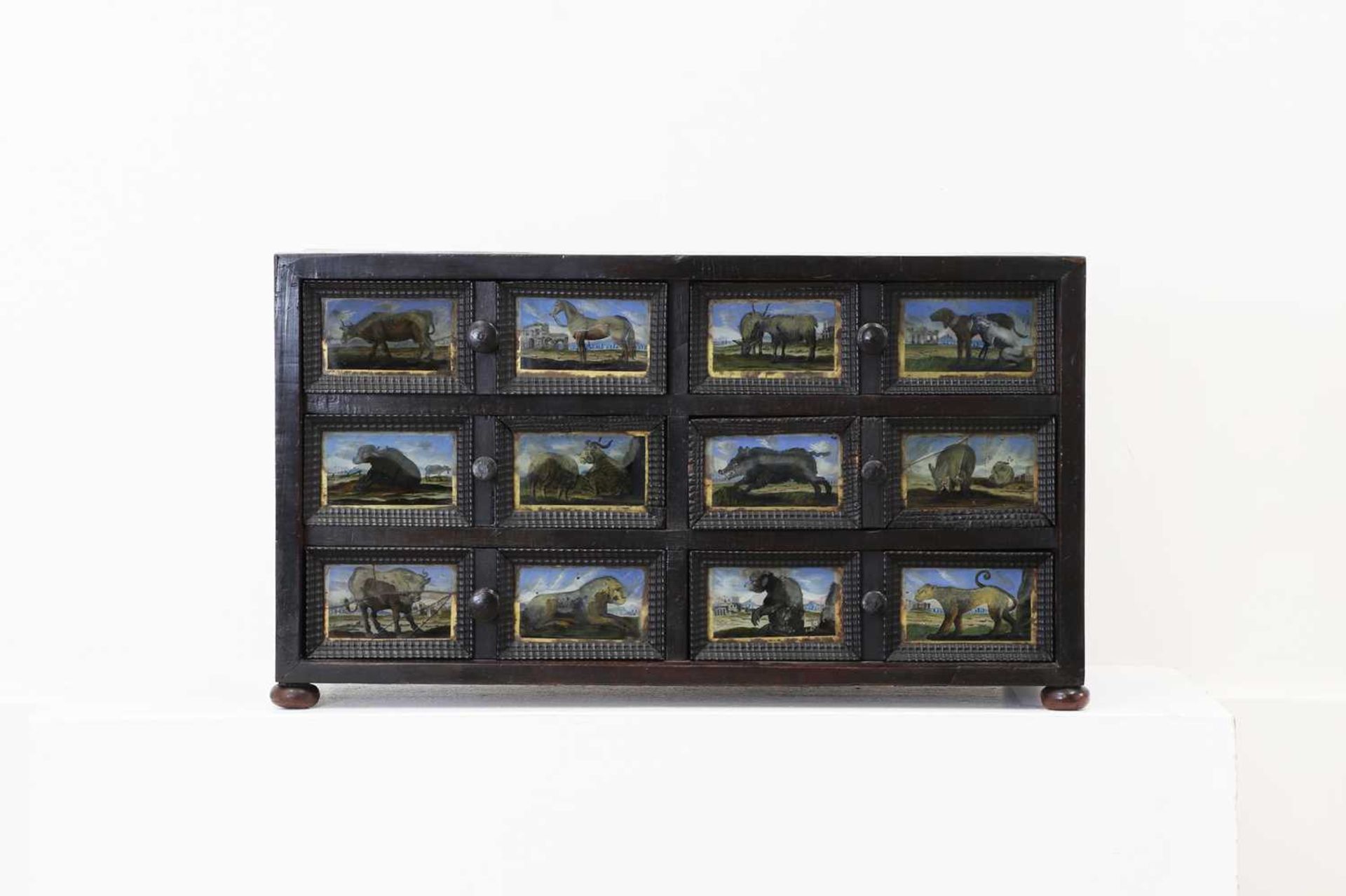 A baroque walnut, ebonised and verre églomisé table cabinet,