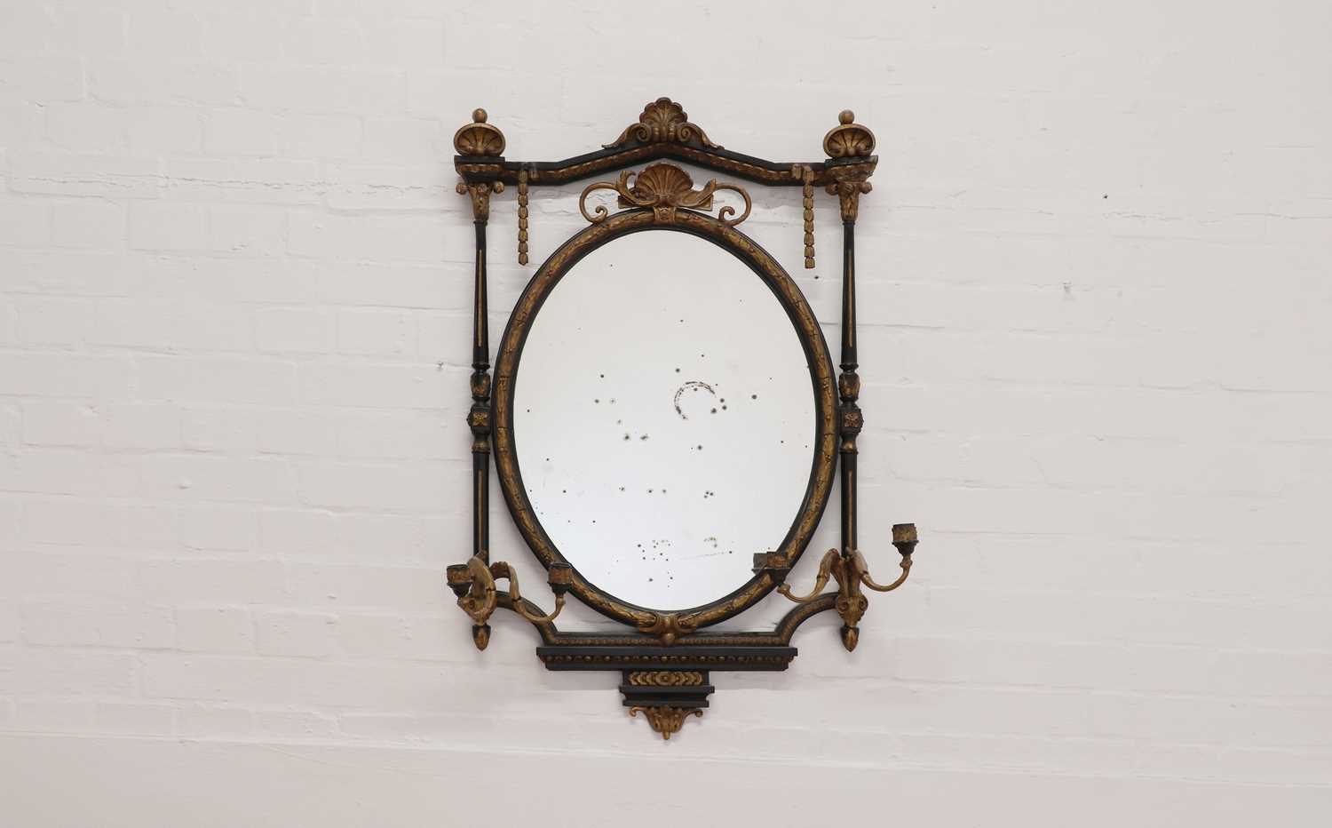 An ebonised and gilt girandole wall mirror,