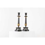 A pair of Regency bronze and painted gilt candlesticks,