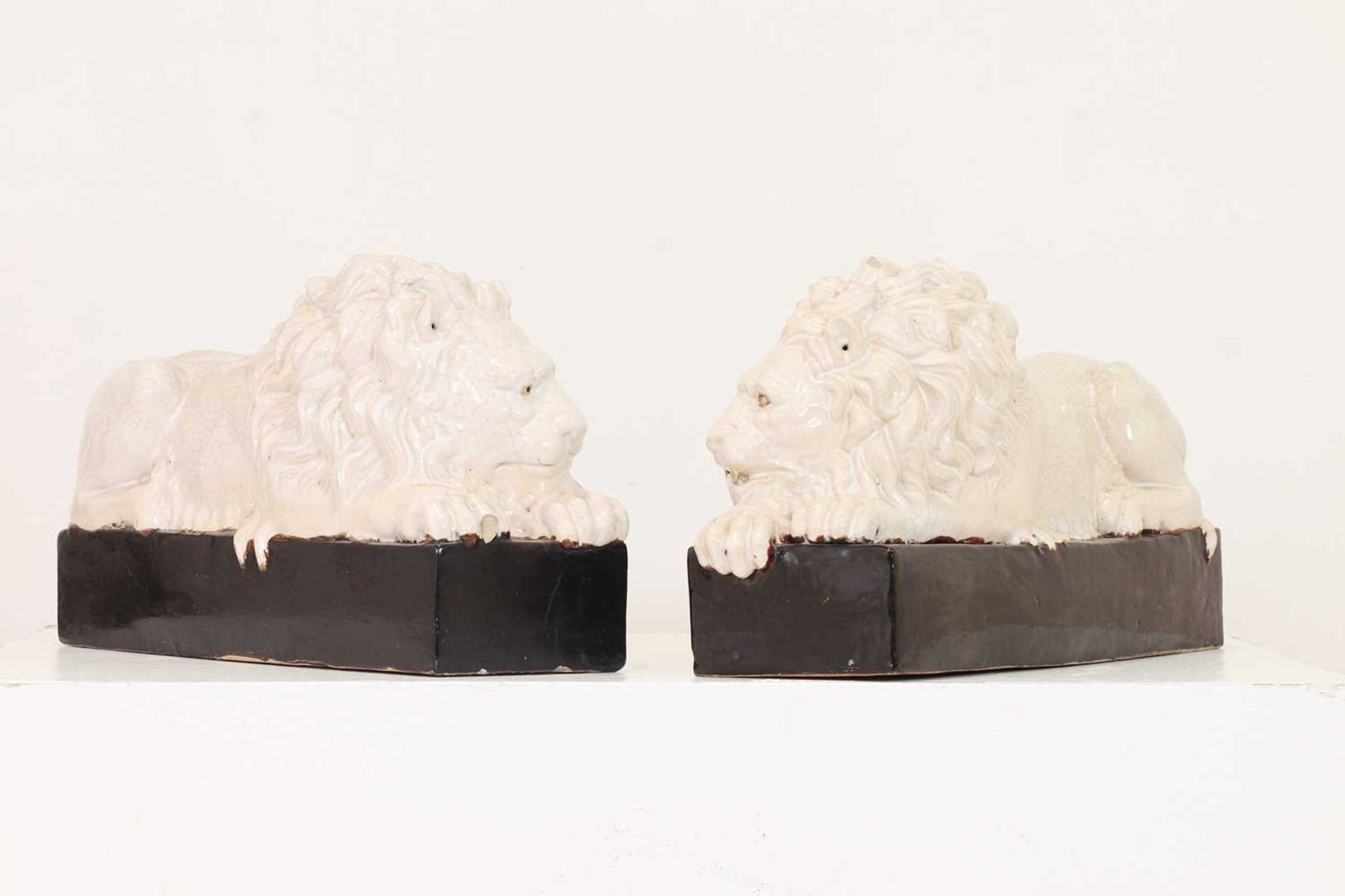 A pair of large glazed lions after Antonio Canova,