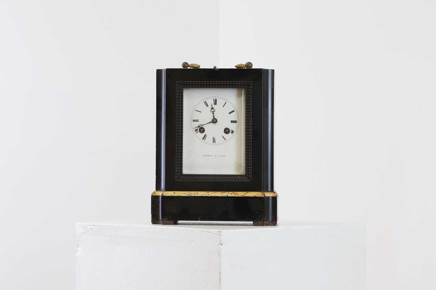 An ebonised and painted table clock,