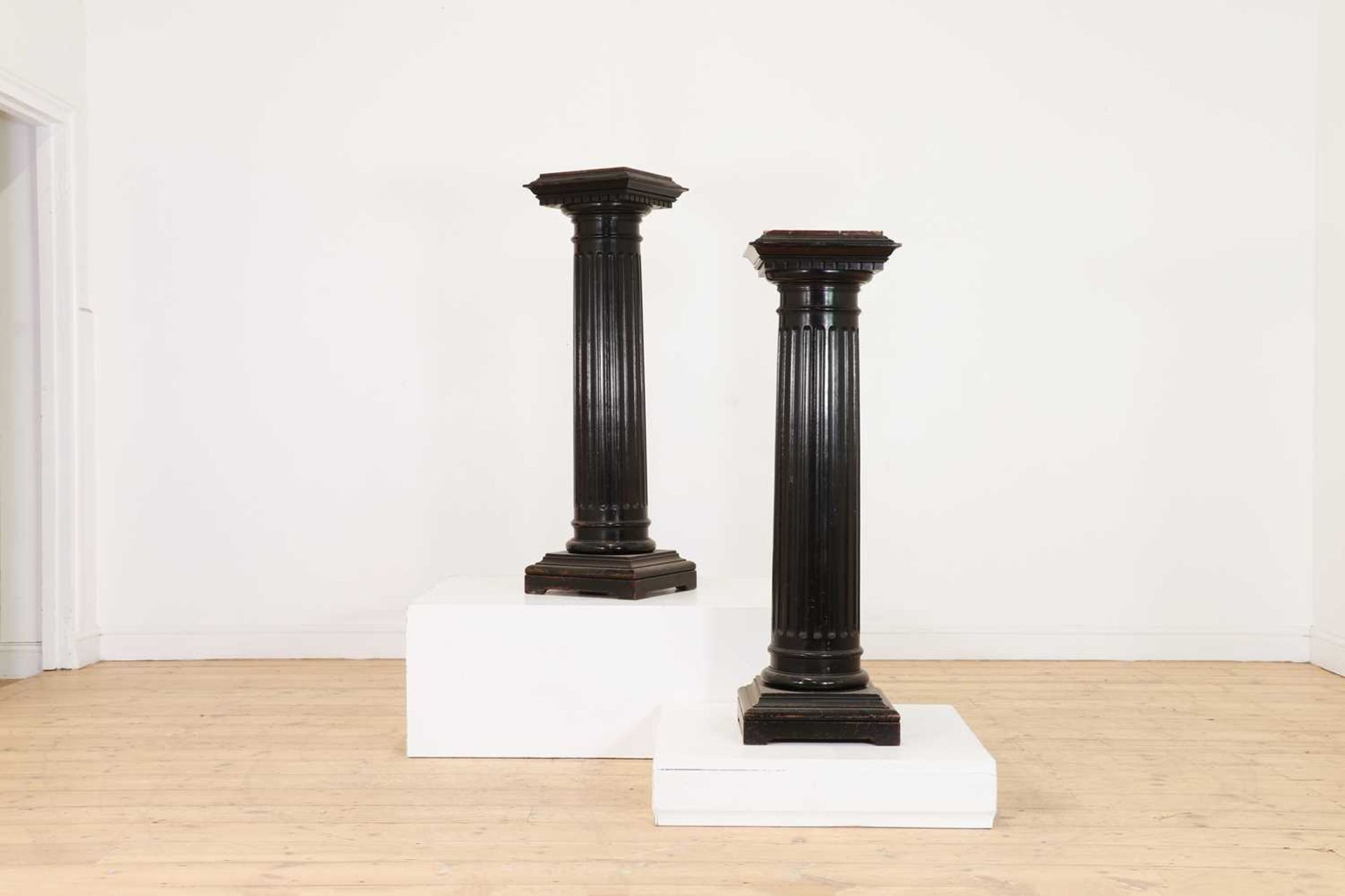 A pair of ebonised wooden columns,