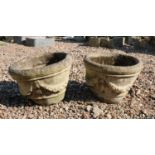 A pair of composite stone weathered garden urns
