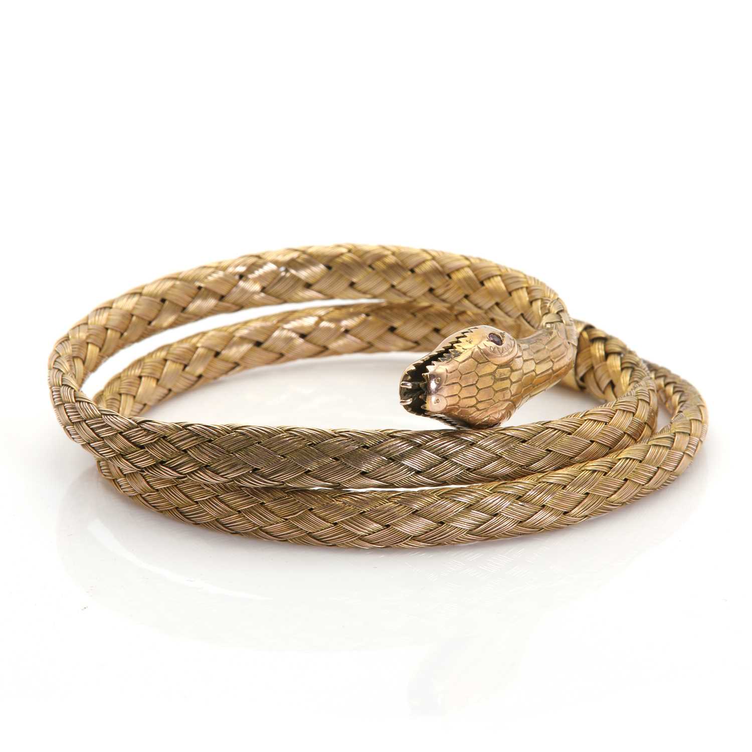 A gold coiled snake flexible bangle,