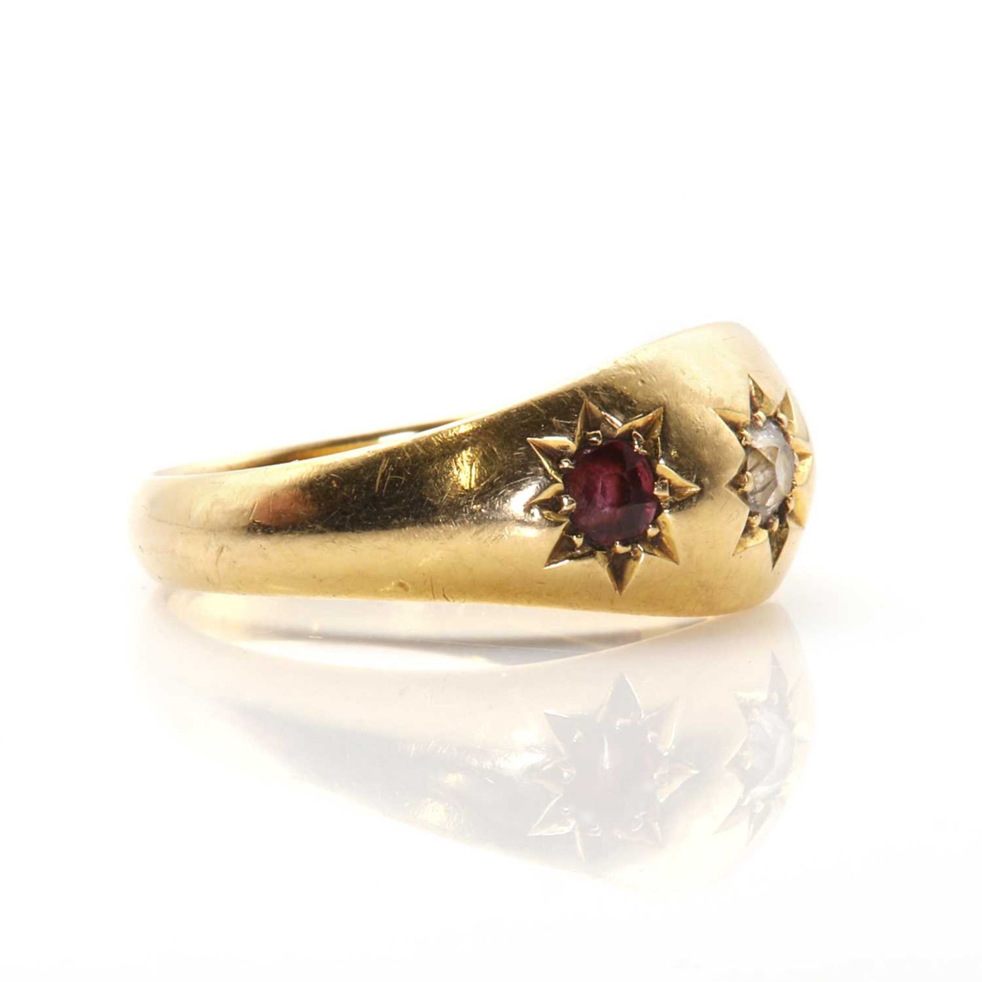 An 18ct gold diamond and garnet three stone ring, - Image 2 of 3