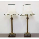 A pair of brass Corinthian column table lamps and shades