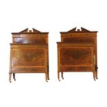 A pair of Edwardian strung mahogany single bed ends