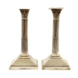 A pair of Corinthian column silver candlesticks,