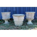 A pair of composite stone footed urns