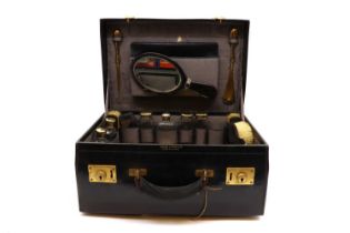 A black leather travelling vanity set,