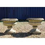 A pair of composite stone urns