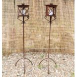 A pair of iron garden candle stands