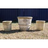 A group of three composite stone garden urns